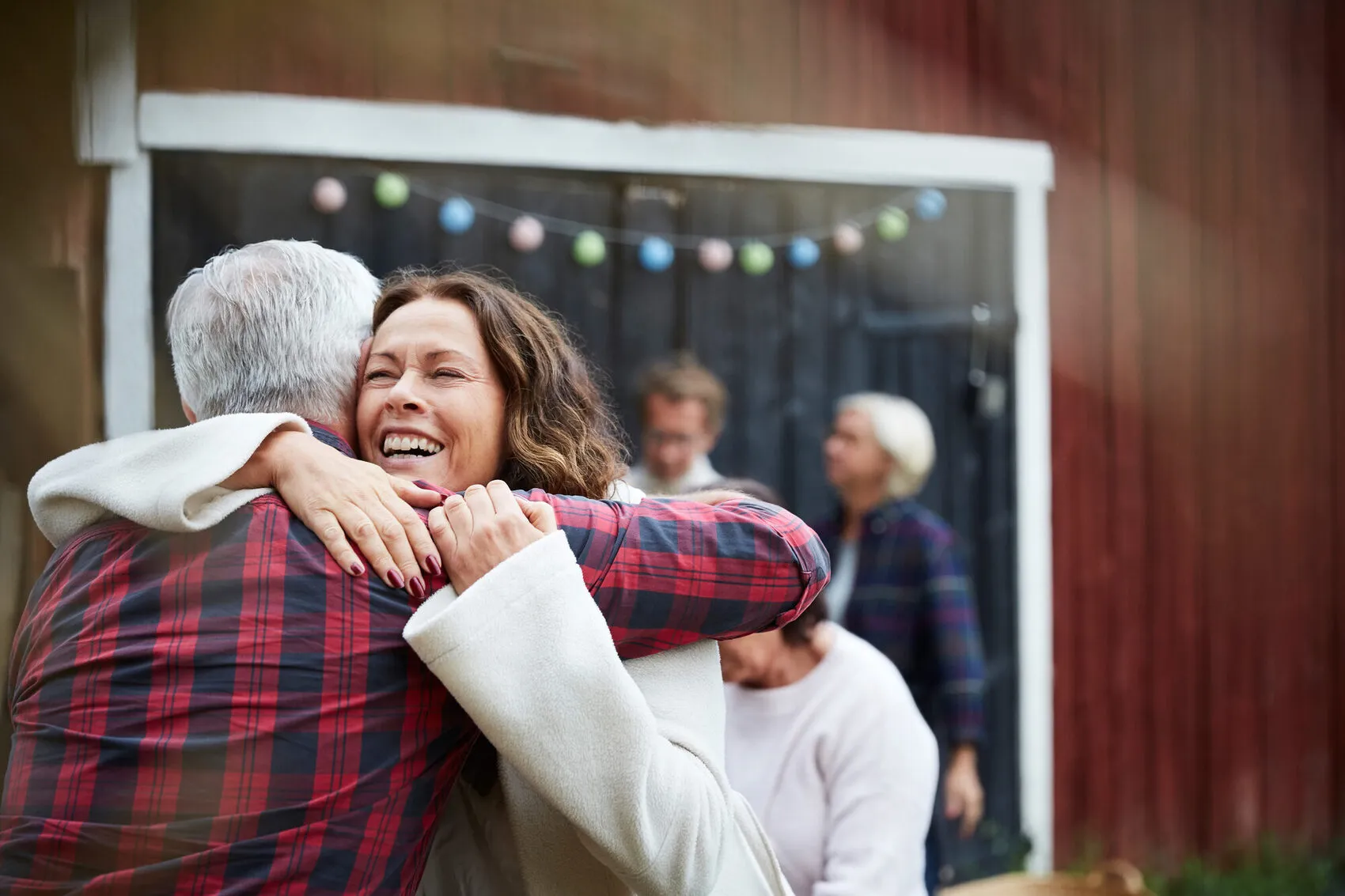 A family joyfully welcoming a senior loved one home with a warm hug in Bellevue
