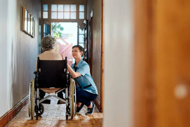 A senior man using a wheelchair at the doorway of his home, part of SYNERGY HomeCare's in-home disability care