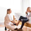 A SYNERGY HomeCare caregiver carefully helping a senior on the steps at home